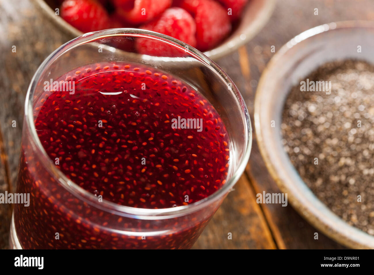 La semilla de chía y frambuesa orgánica en un trasfondo de bebidas Foto de stock