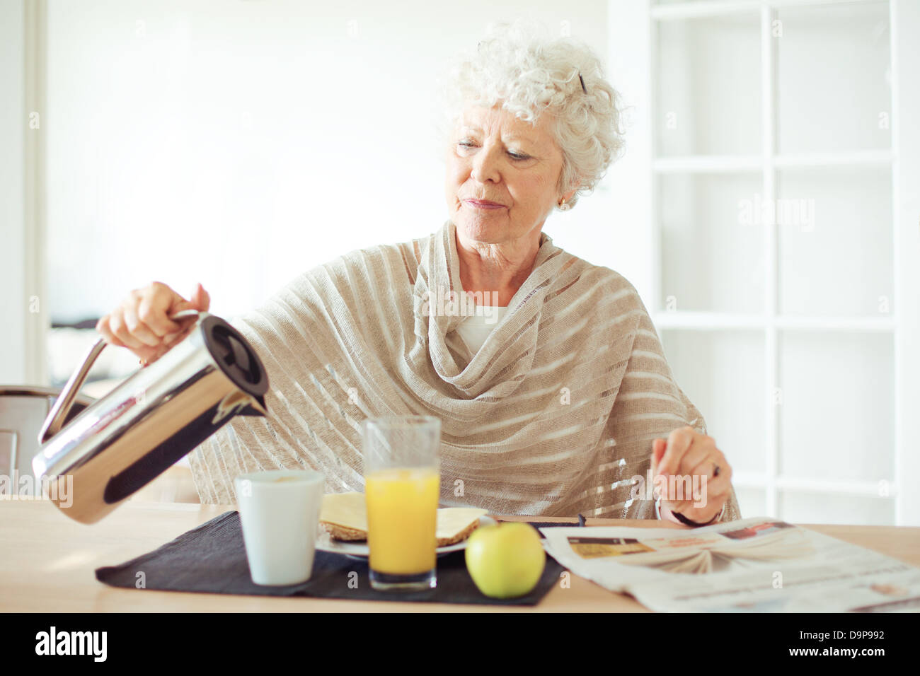 Retrato de una mujer mayor tener desayuno saludable en casa Foto de stock
