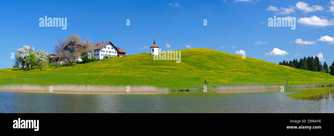 Paisaje Panorámico de Baviera con capilla y casa de granja en el lago Foto de stock