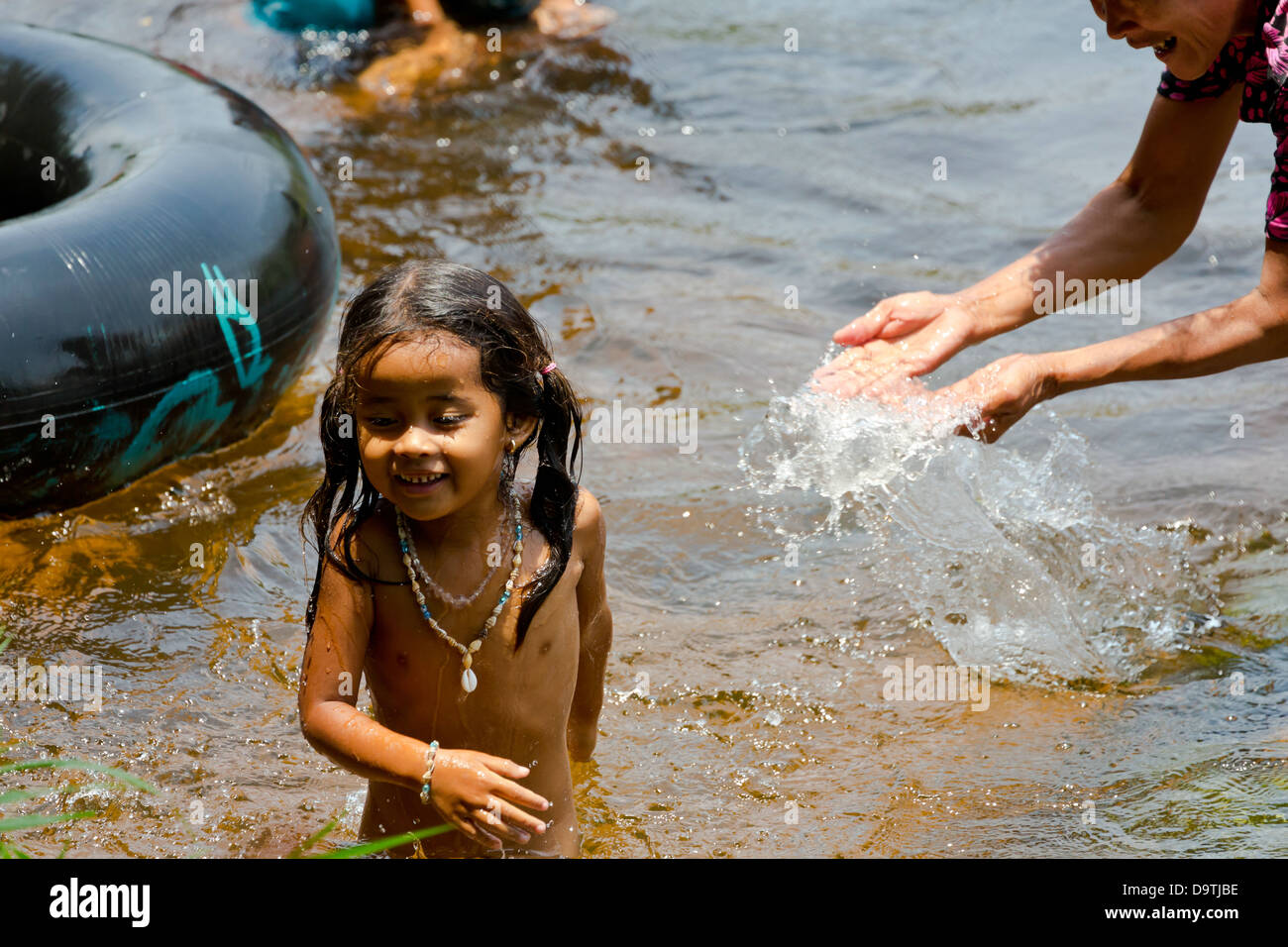 Niña tomando un baño en el río fotografías e imágenes de alta