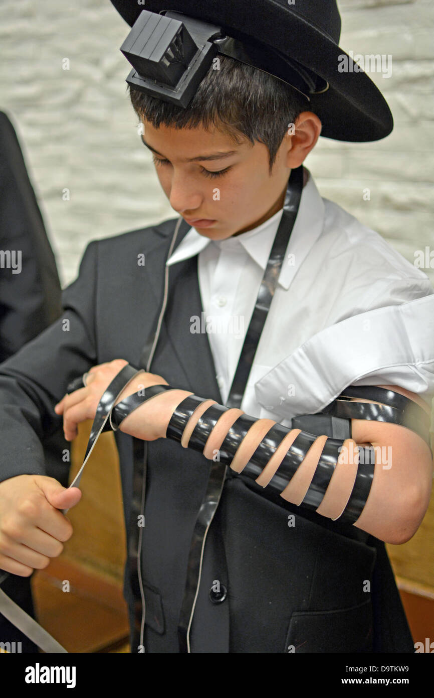 Los jóvenes religiosos chico judío pone sobre tefillin phylacteries