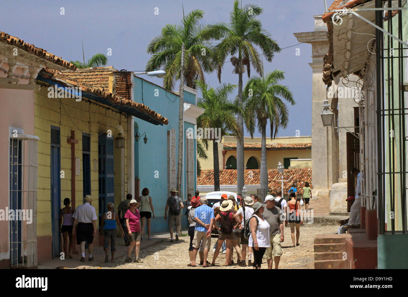Los turistas stand inbetween edificios con las típicas rejillas curvados hacia afuera facilitando la comunicación entre el interior y el exterior en Trinidad, Cuba, 15 de abril de 2013. Foto: Peter Zimmermann Foto de stock
