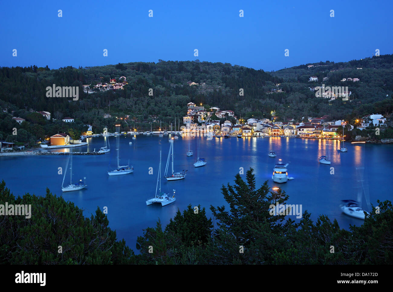 Vista de noche de Lakka Bay Village, y la isla de Paxos, Mar Jónico, Eptanisa ('Sincluso islas'), Grecia. Foto de stock