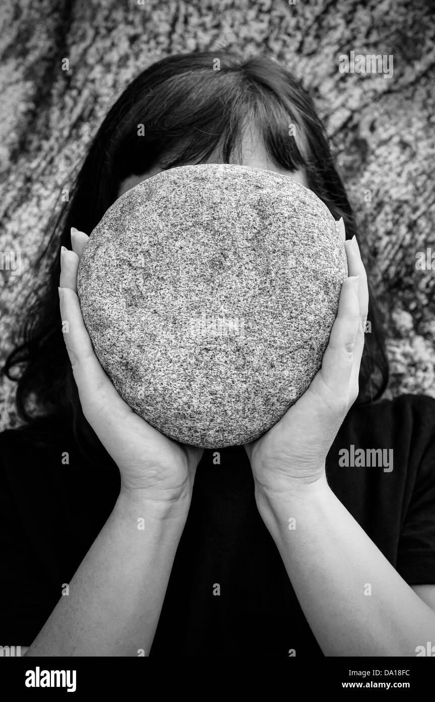 Mujer sosteniendo una piedra grande Foto de stock