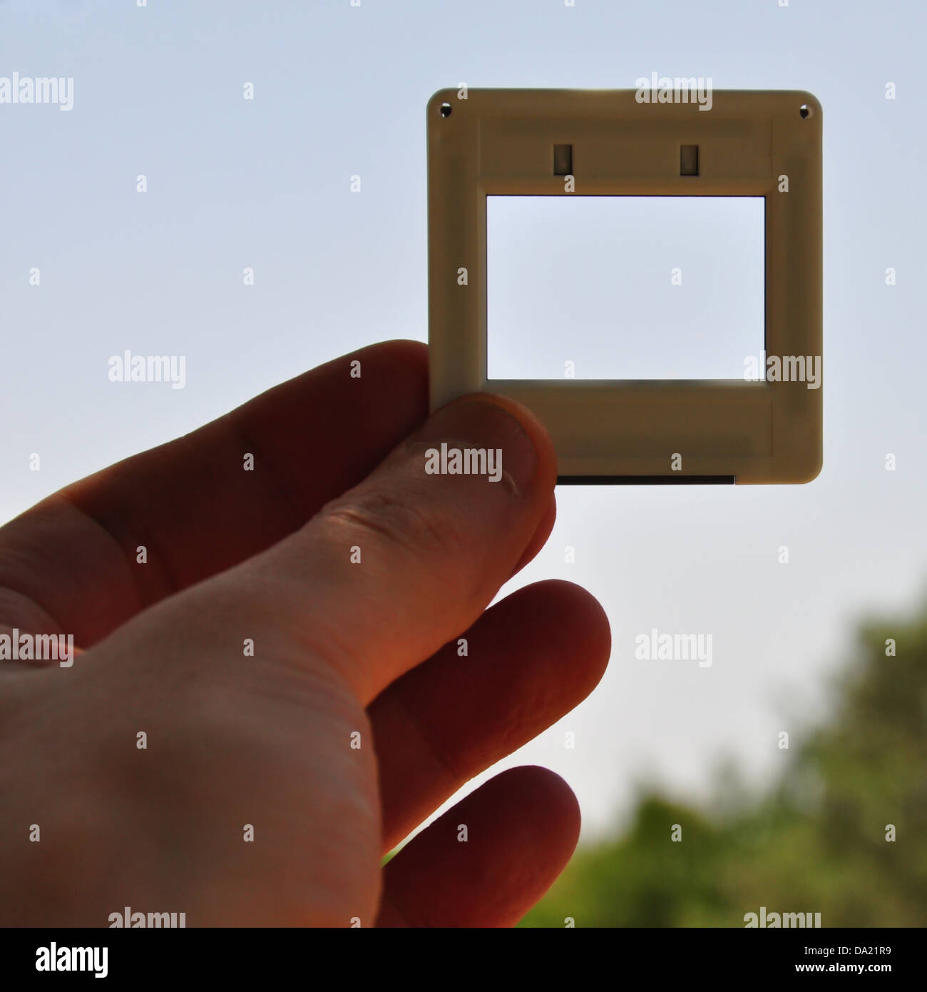 Mano con diapositiva fotográfica en blanco el marco de imagen. Coloque su propia imagen o texto. Foto de stock