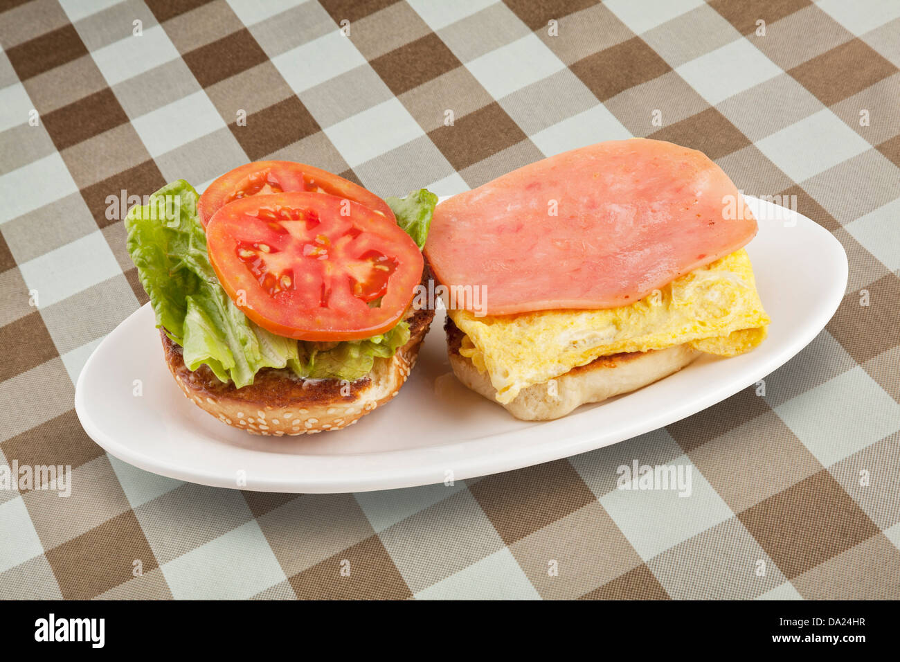 Un delicioso desayuno de huevos, jamón, lechuga y rodajas de tomate Foto de stock