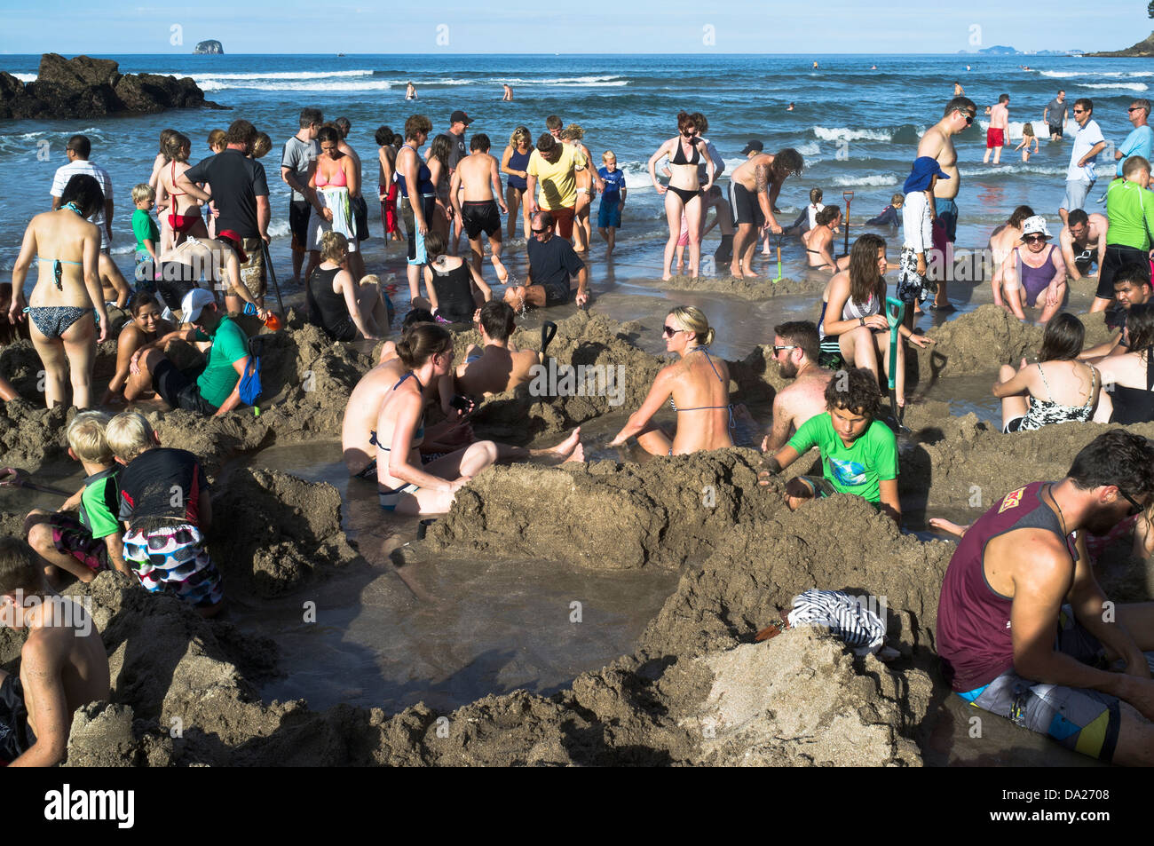 Dh Playa Agua Caliente NUEVA ZELANDIA COROMANDEL personas yacen en manantiales piscinas termales geotérmicas peninsula Foto de stock