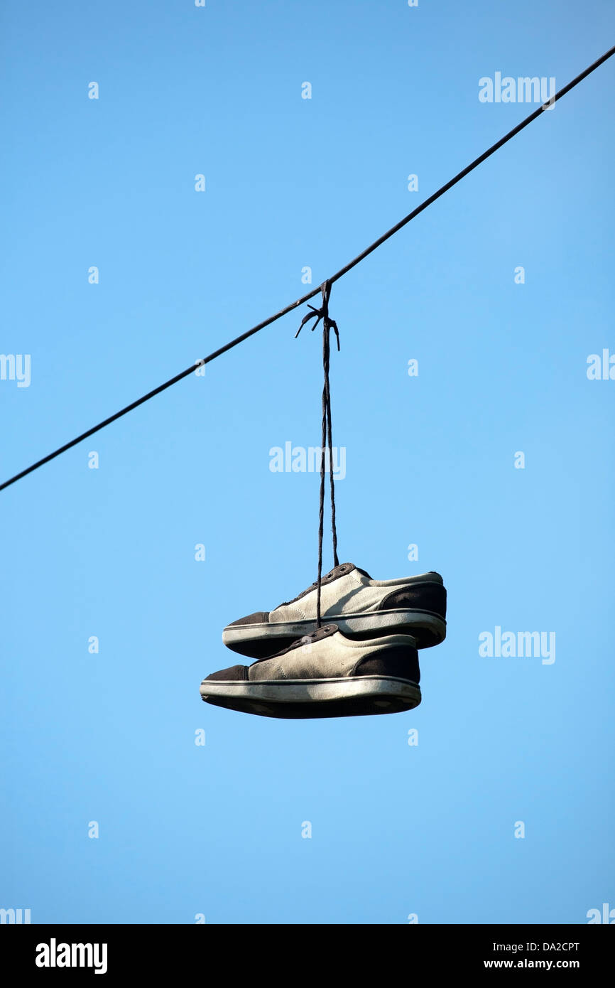 Par de zapatos colgados de un cable eléctrico Fotografía de stock - Alamy