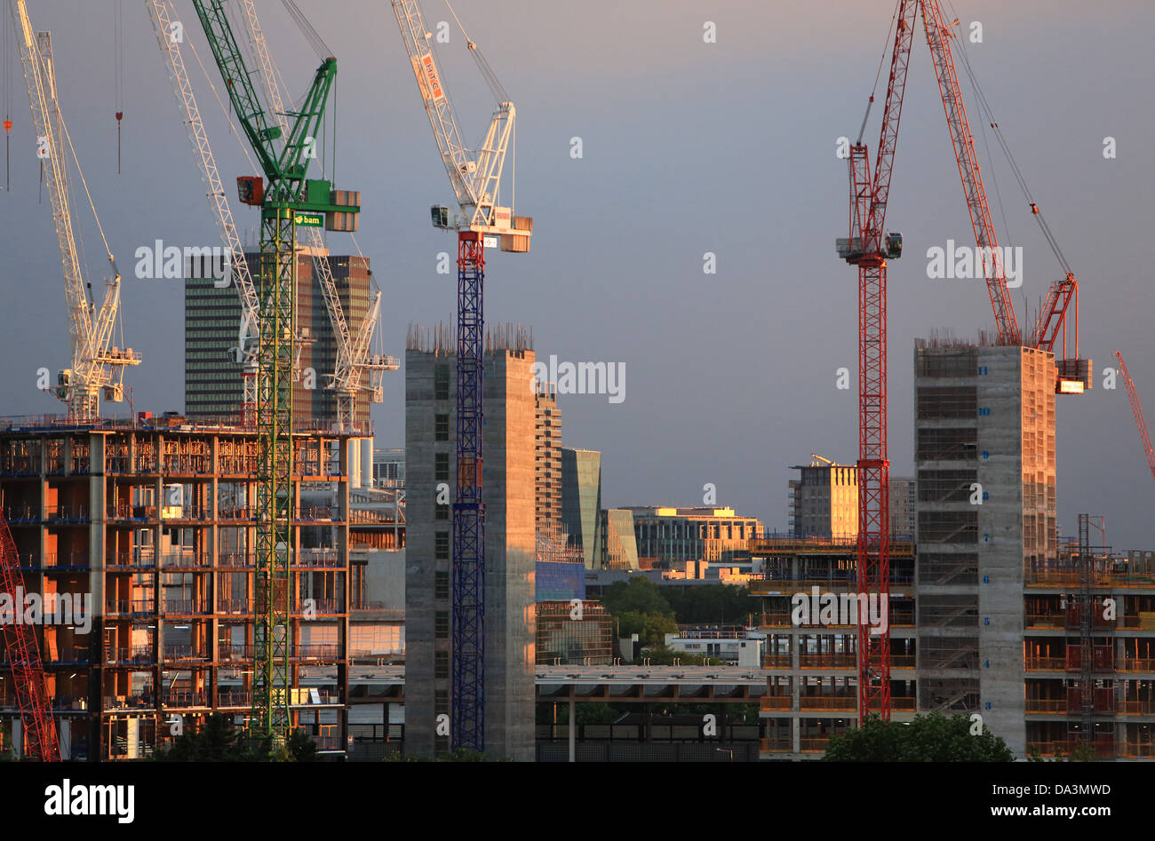 Grúas de construcción en el norte de Londres, detrás de la estación de St Pancras, al anochecer, en Inglaterra, Reino Unido. Foto de stock