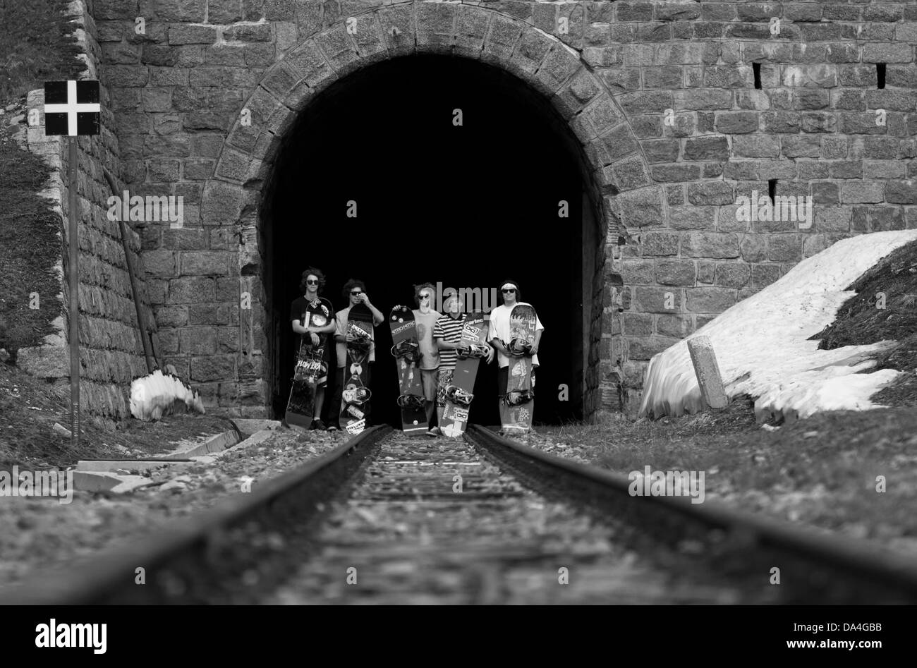 FURKA, Valais, Suiza. Un grupo de hombres snowboarder posando con sus tablas de snowboard en frente de un túnel de ferrocarril. Foto de stock