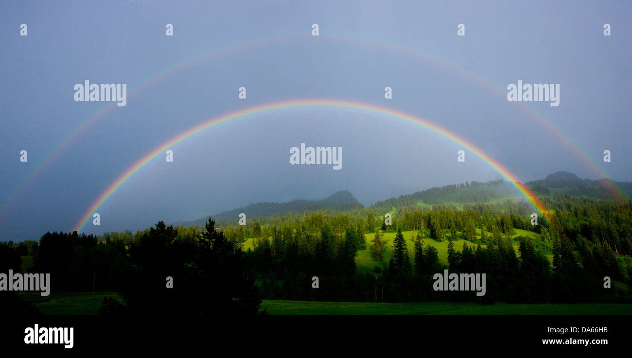 Rainbows, Saanenland, meteorología, nubes, nubes, cantón de Berna, Saanenmöser, Gstaad, madera, bosque, panorama, Suiza, Europa, Foto de stock