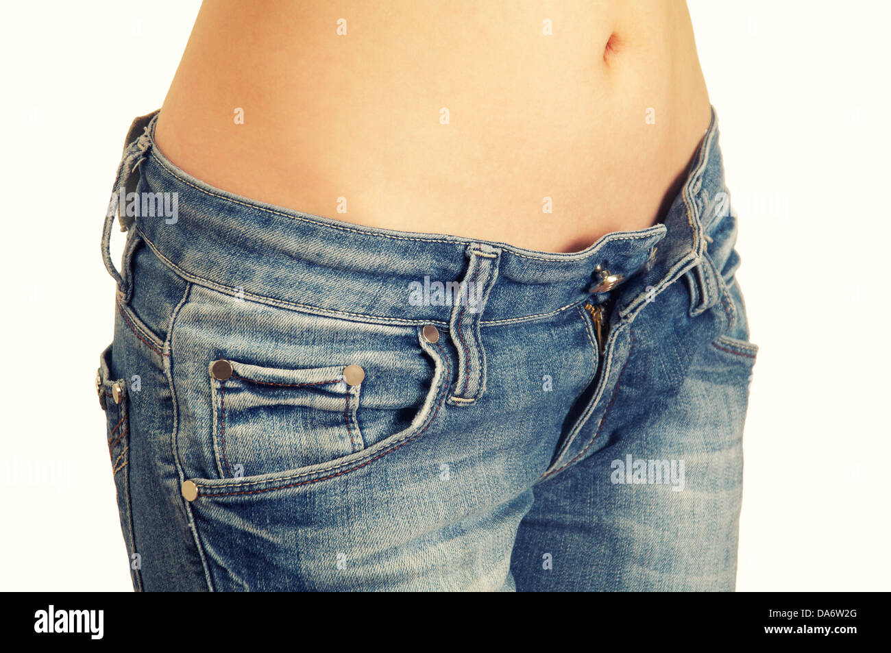 Mujer joven mostrando su perfecta cintura y jeans abierto aislado sobre  fondo blanco Fotografía de stock - Alamy