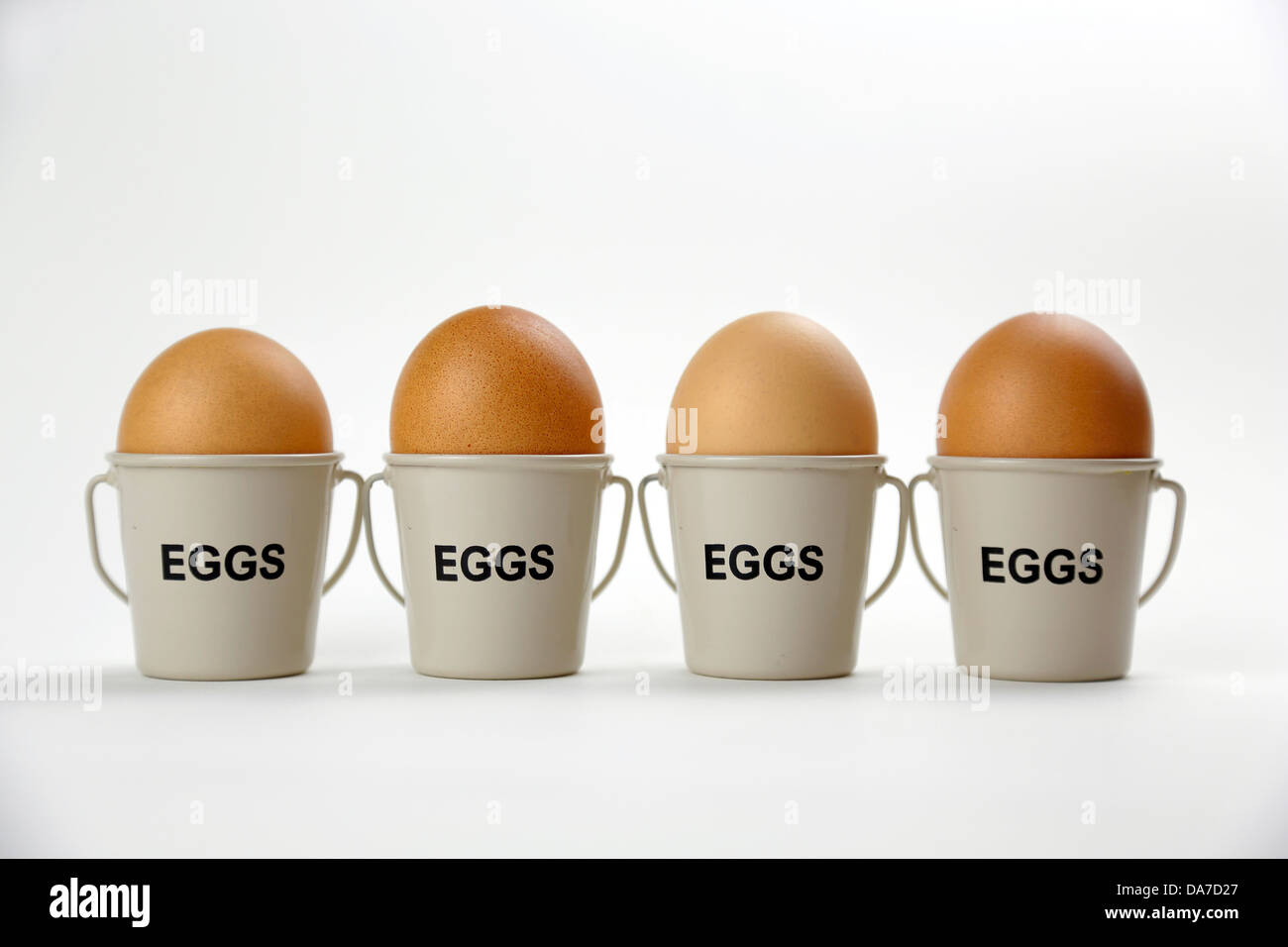 Huevos cocidos en tazas en una fila Foto de stock