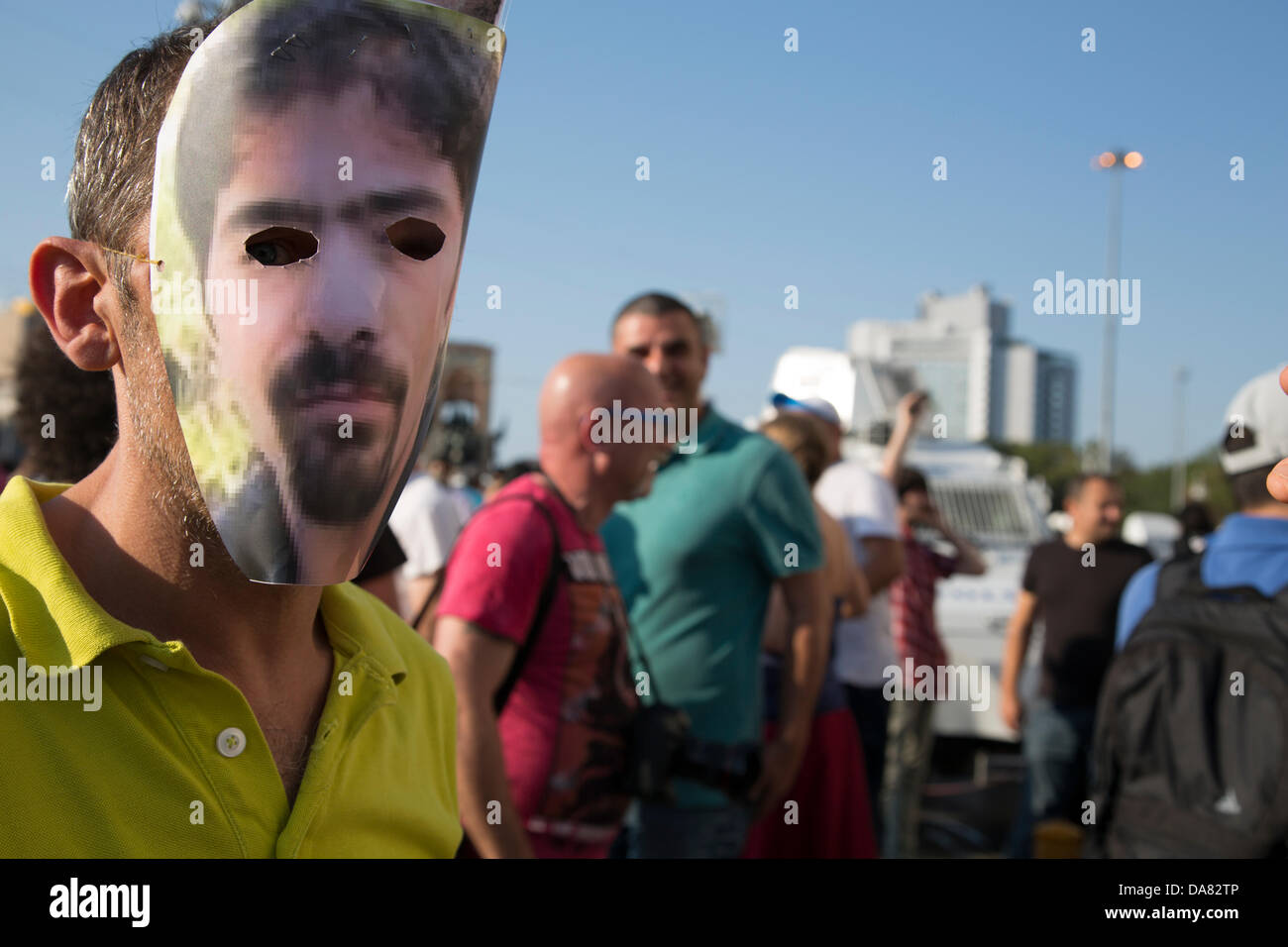Estambul, Turquía -- un manifestante usando el recorte foto de Ethem Sarisuluk el rostro como una máscara hecha en casa. Ethem, un joven civil, fue asesinado por una bala de la policía a la cabeza, y el autor fue puesto en libertad, ya que el tribunal resolvió "autodefensa" en favor de los policías involucrados. La plaza Taksim, en Estambul. Julio, 07, 2013. Foto por Bikem Ekberzade Foto de stock