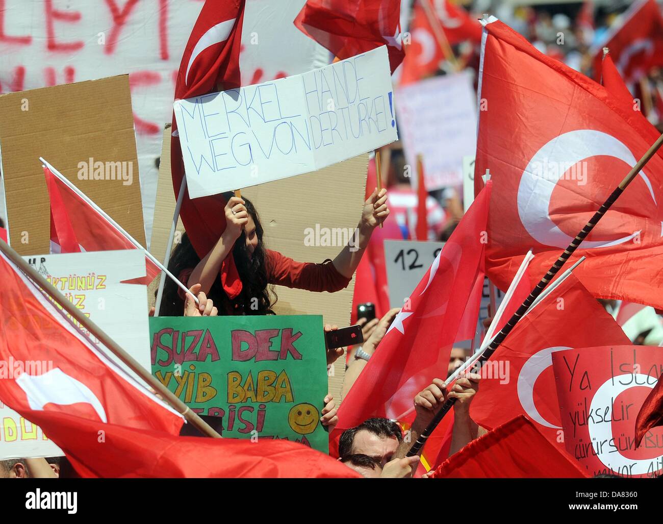 En Dusseldorf, Alemania. 07 de julio, 2013. Los manifestantes llevan banderas y carteles durante una manifestación para mostrar su apoyo a primer ministro turco Erdogan en Duesseldorf, Alemania, 07 de julio de 2013. La manifestación bajo el lema 'democracia - Eventos actuales en Turquía" fue organizado por la Unión de Demócratas European-Turkish. Foto: HENNING KAISER/dpa/Alamy Live News Foto de stock
