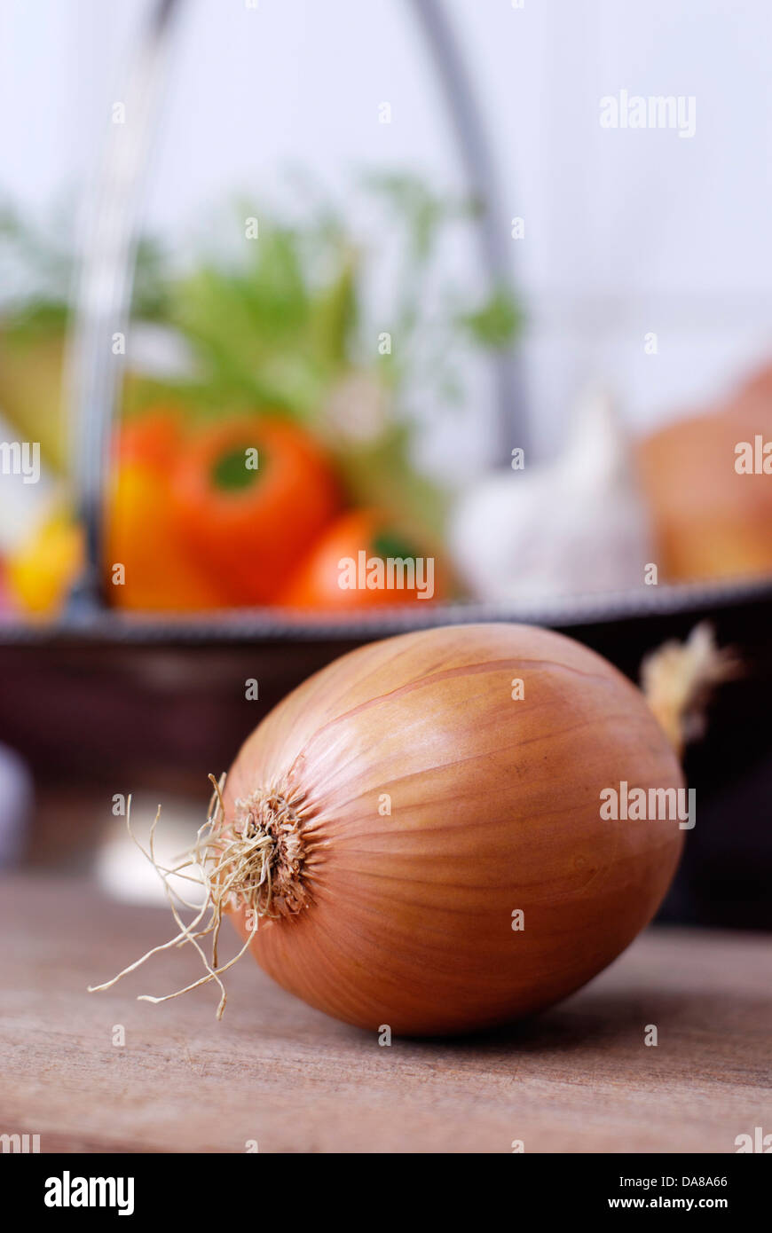 Una cebolla con verduras en segundo plano. Foto de stock