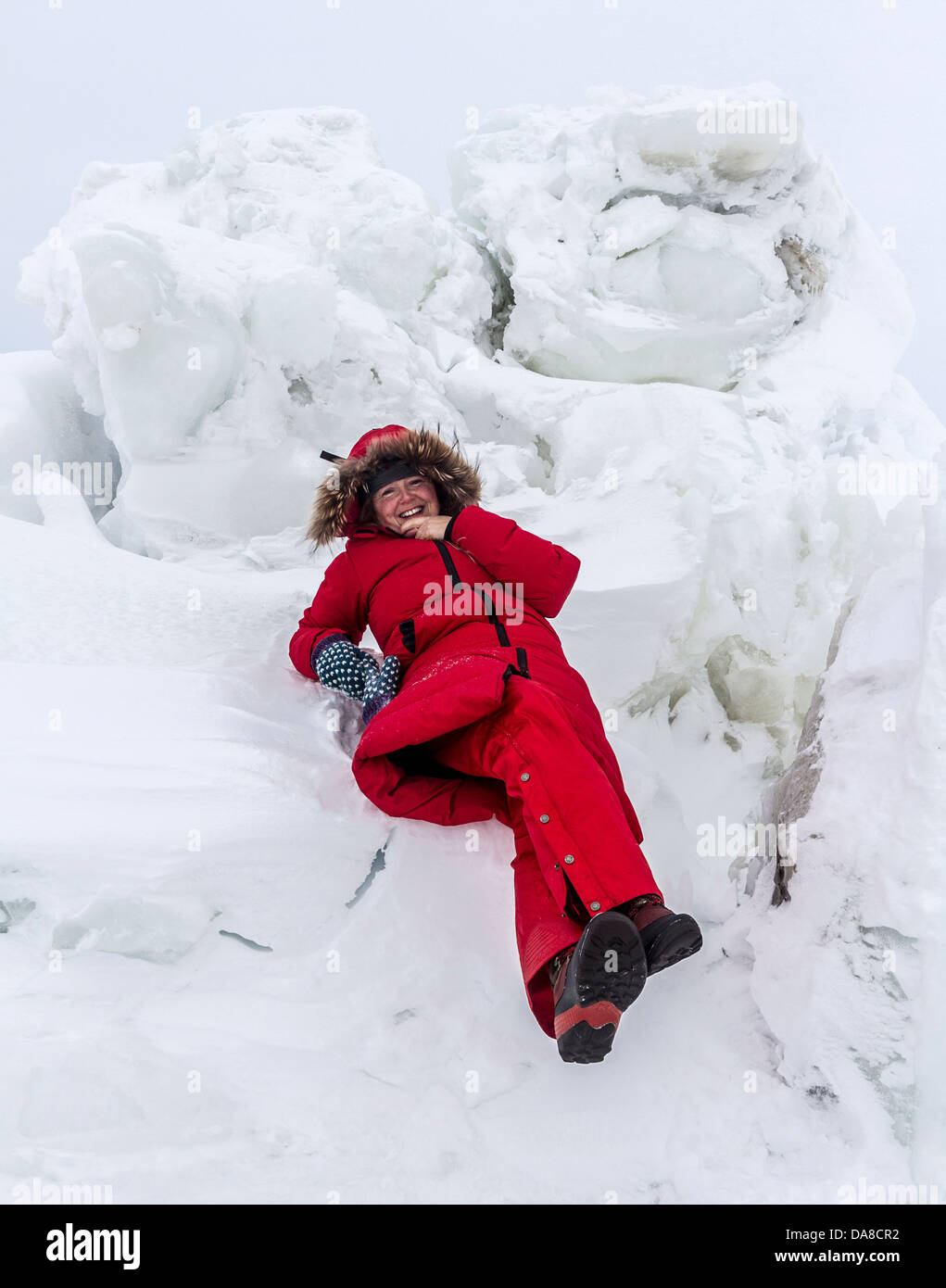 La mujer desempeña entre los bloques de hielo creado por la acción de las mareas en el borde de la Bahía de Hudson a finales de invierno. Churchill, Manitoba, Canadá. Foto de stock