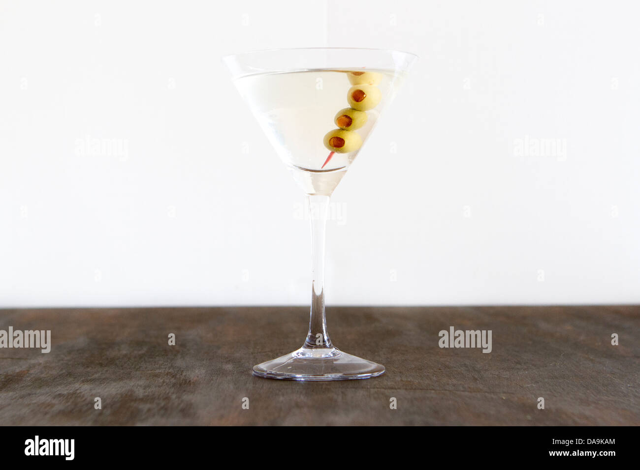 Un martini en un estudio telón de fondo con las aceitunas. Foto de stock