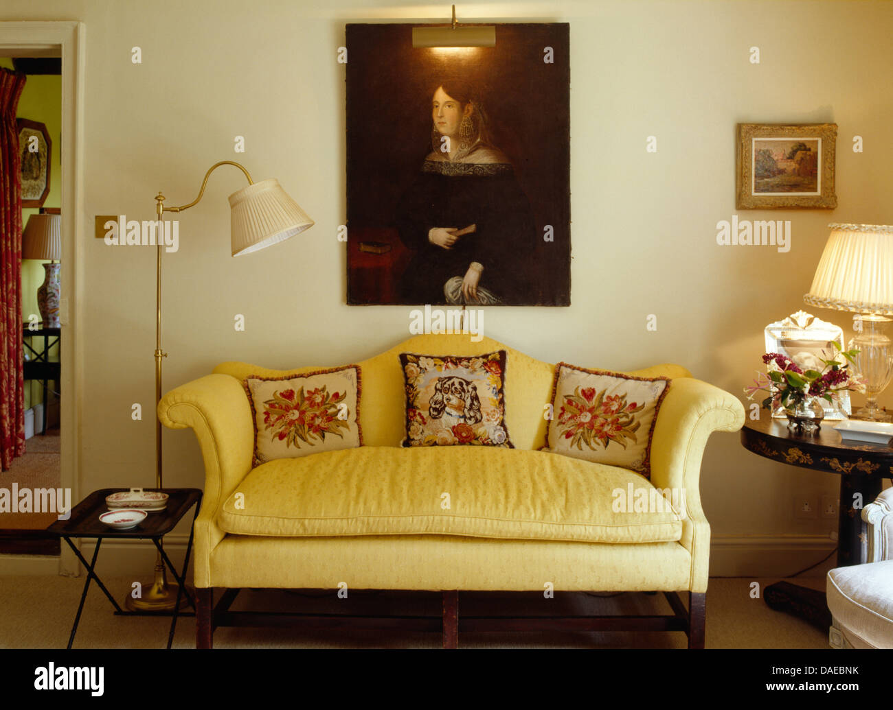 Gran Retrato de aceite encima de sofá amarillo con tapices cojines en casa  en la sala de estar, con lámpara de suelo Fotografía de stock - Alamy