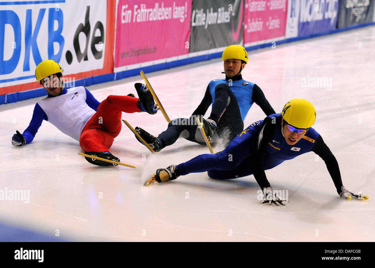 Im Herren-Finale über die 500 metros stürzen am Samstag (19.02.2011) en der Eishalle en Dresden im Rahmen des Weltcup-Finales im Shorttrack Frankreichs Teobaldo Fauconnet (l), der US-Amerikaner Simon Cho (M) sowie der Südkoreaner Byeong-Jun Kim auf der Ziellinie, Fauconnet wurde später als Sieger vor Cho gewertet, Kim wurde disqualifiziert. Un diesem Wochenende trifft sich die Weltel Foto de stock
