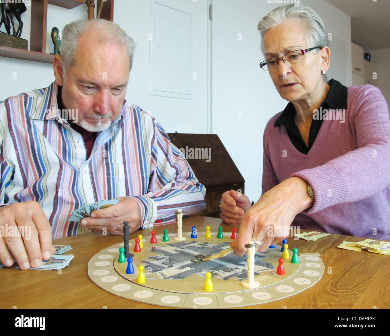 Desarrollador de Juegos Wolfgang Kramer (L) y su esposa Ursula desempeñar  un prototipo del nuevo juego de mesa 'Artus' en su piso en Stuttgart,  Alemania, 07 de diciembre de 2011. Wolfgang Kramer