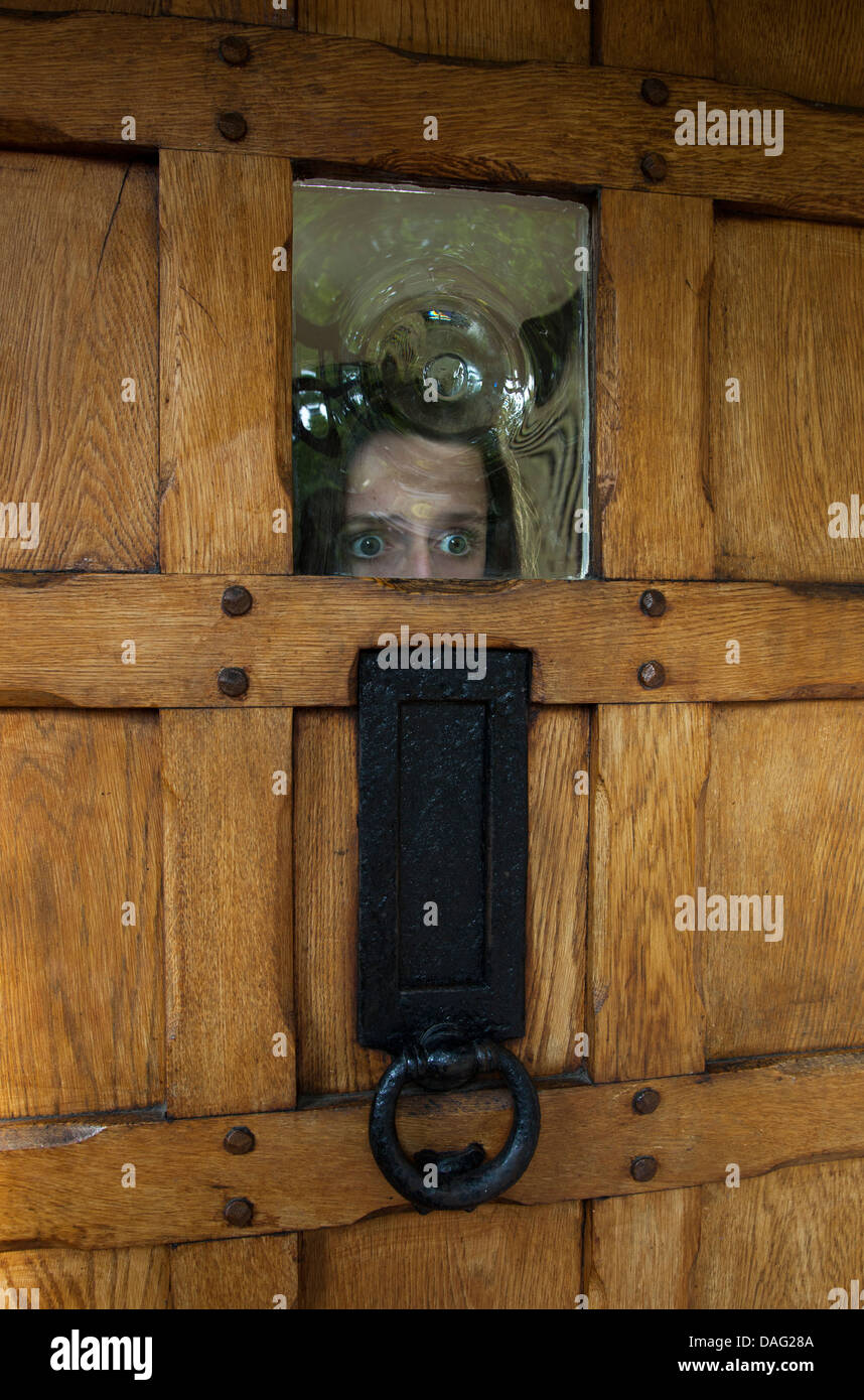 El terror, la niña mirando a través del vidrio de la puerta delantera  Fotografía de stock - Alamy