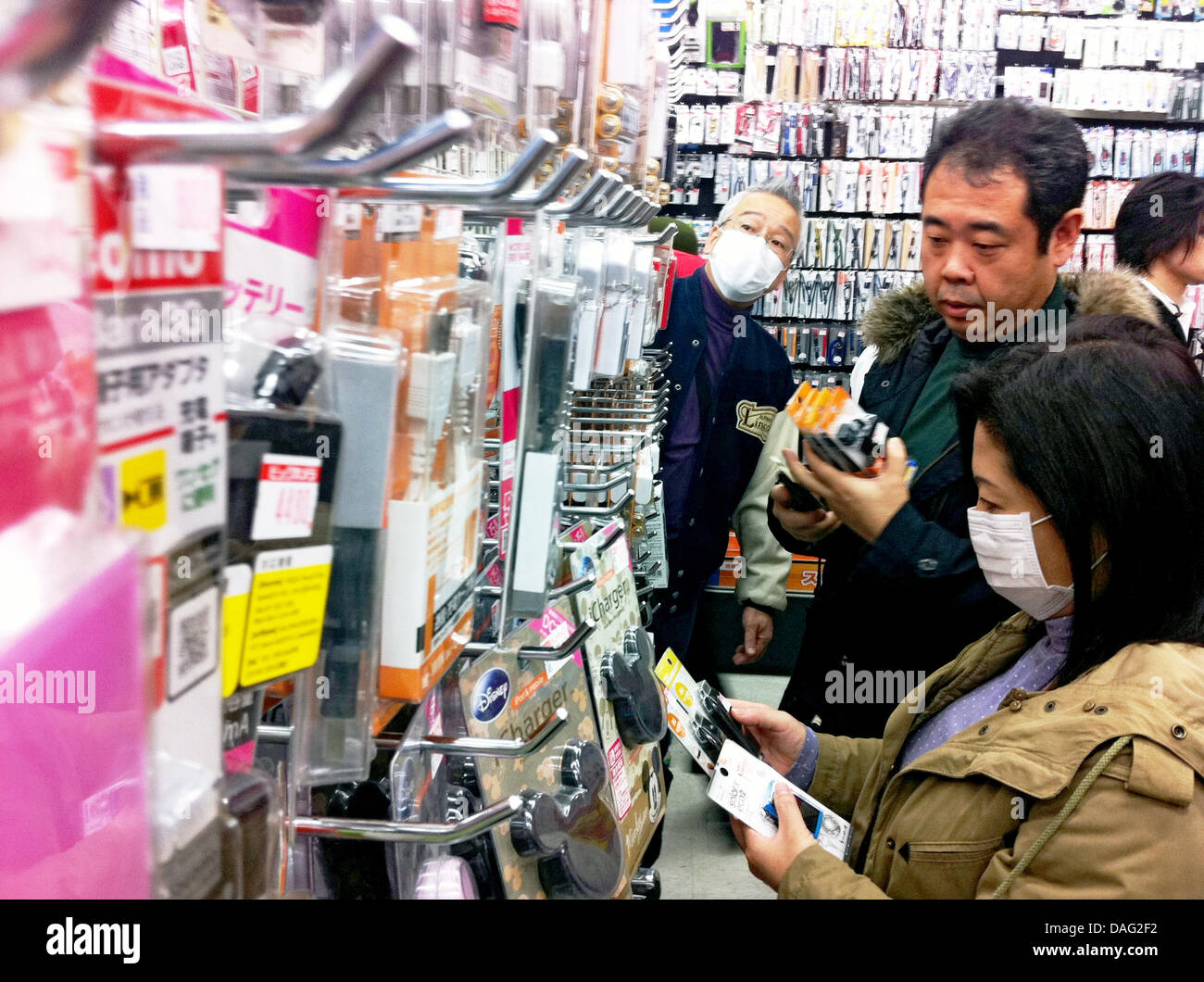 Japaner kaufen am Sonntag (13.03.2011) en Tokio en einem Geschäft für Elektronik batteriebetriebene Ladegeräte für Handys um auch bei einem längeren telefonieren Stromausfall weiter zu können. Schweres Erdbeben hatte Ein am Freitag (11.03.2011) Japón erschüttert. Foto: Aníbal Foto de stock