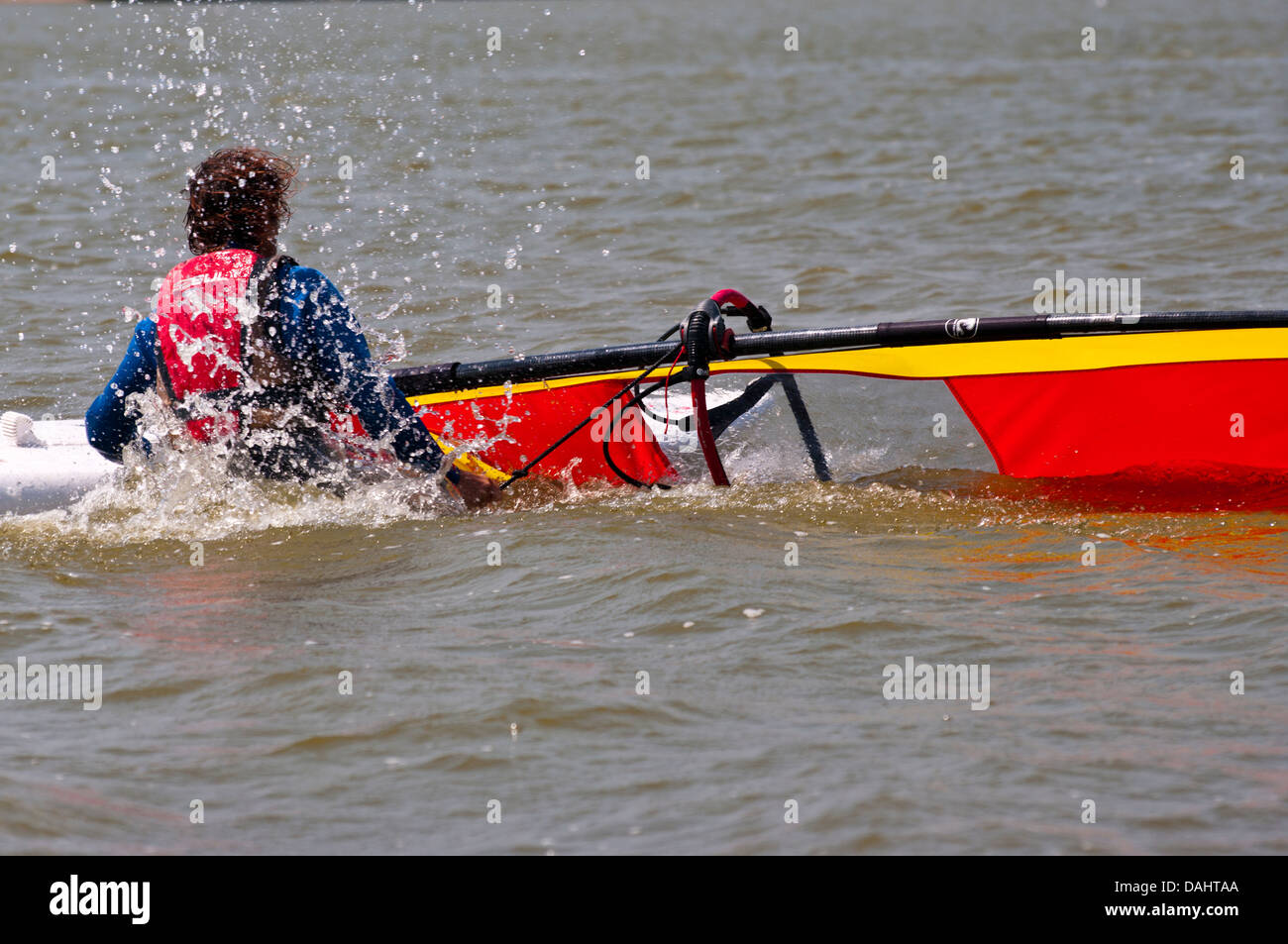 La windsurfista caída de su junta en el agua UK Foto de stock