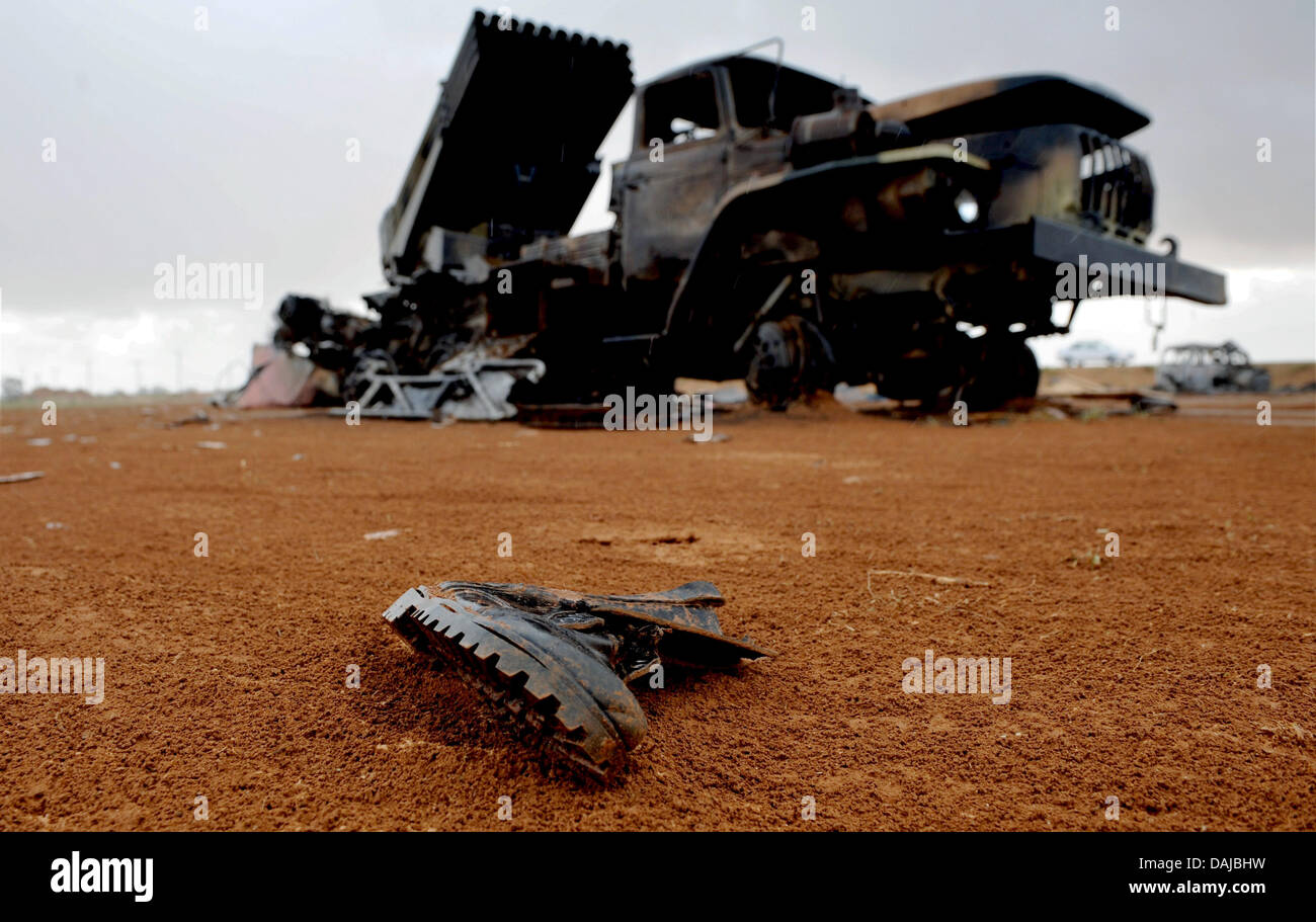 Perdió una Bota de combate radica en la arena delante de los restos de un lanzador de cohetes Katyusha en Bengasi, Libia, 01 de abril de 2011. Después de unos días de calma, los residentes de Benghazi temen nuevos ataques de Gadafi las tropas. Foto: Maruizio Gambarini Foto de stock