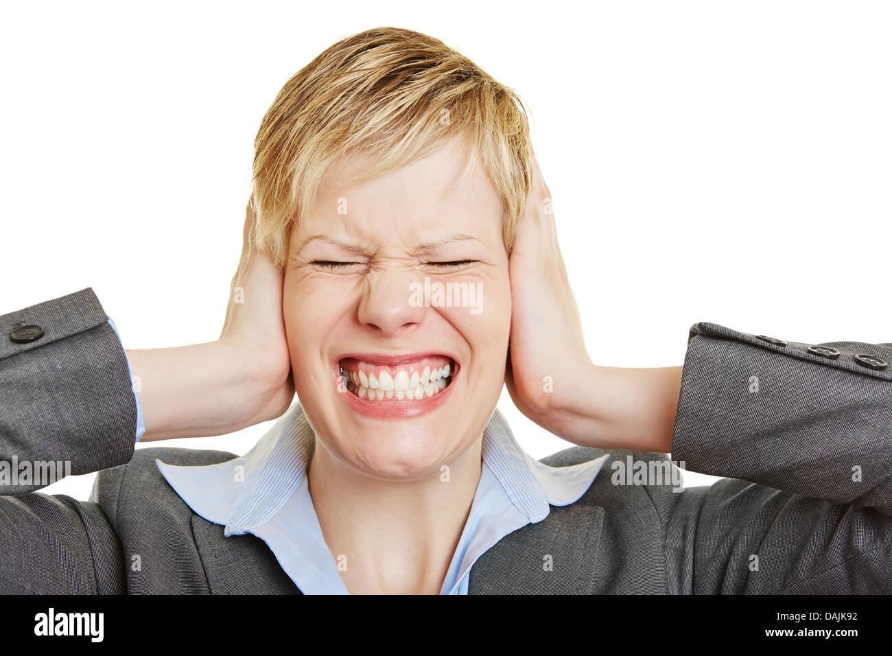 Mujer de negocios jóvenes enojados haciendo una mueca con sus orejas cerradas Foto de stock