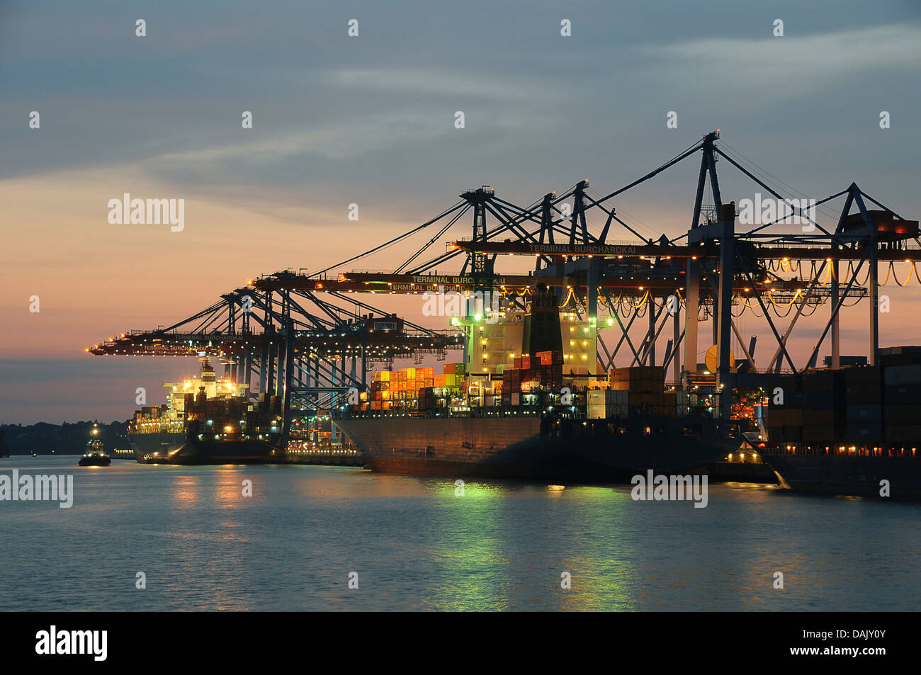 Los buques portacontenedores en el puerto durante la descarga, el anochecer Foto de stock