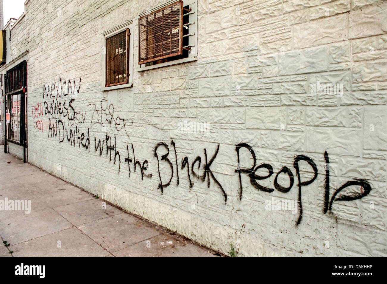 Graffiti pintado con spray en una pared de South Central tras los disturbios raciales de 1992 Rodney King proclama la solidaridad racial. Foto de stock