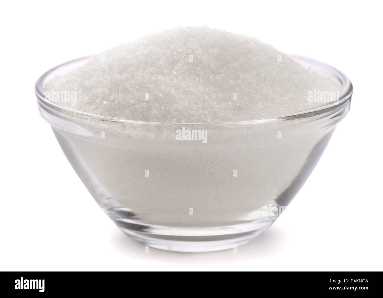 El azúcar en el tazón de vidrio aislado en blanco Foto de stock