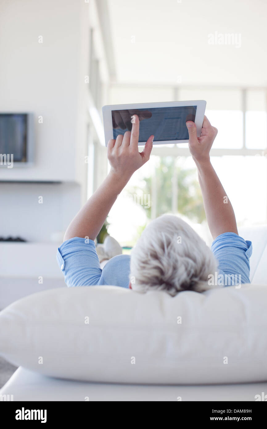 Mujer con tablet PC en el sofá Foto de stock