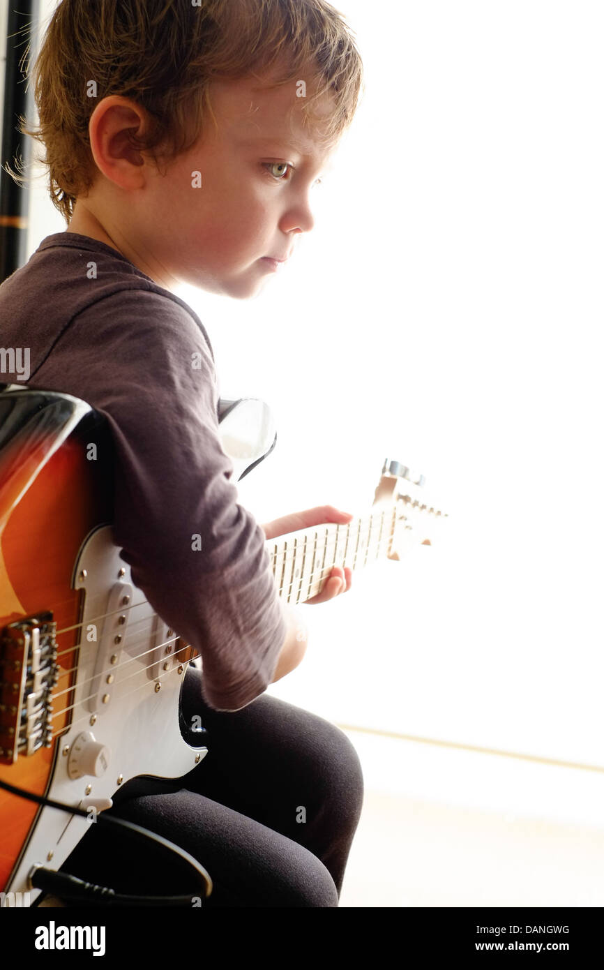 Niño de tres años tocando la guitarra eléctrica Fotografía de stock - Alamy