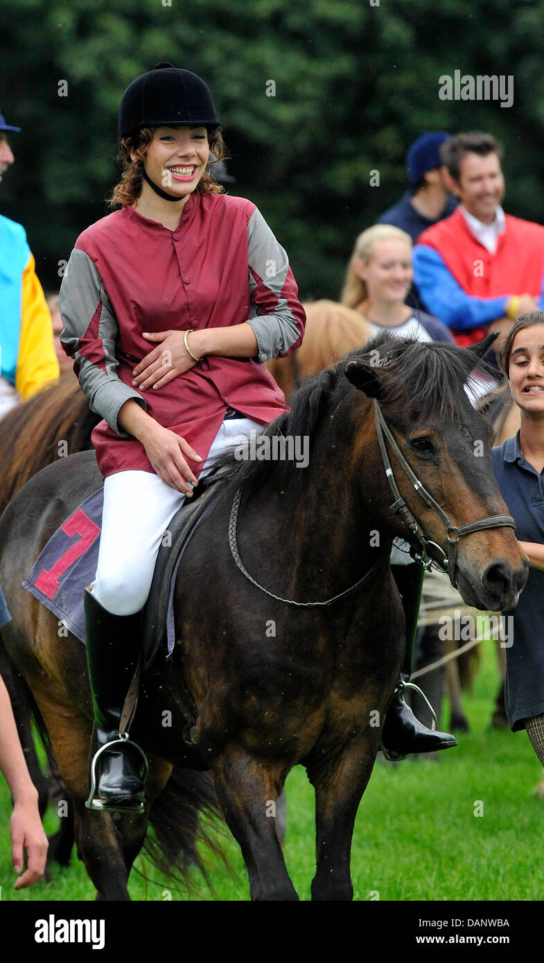 El cantante Edita Abdieski sentada sobre un caballo después de la carrera en el beneficio para el día de la carrera (Alianza de protección infantil Kinderschutzbund) de Colonia en el hipódromo de Colonia, Alemania, el 10 de julio de 2011. Es la décima vez que celebridades han ayudado a la alianza por la protección de los niños recogiendo donaciones. Foto: HENNING KAISER Foto de stock