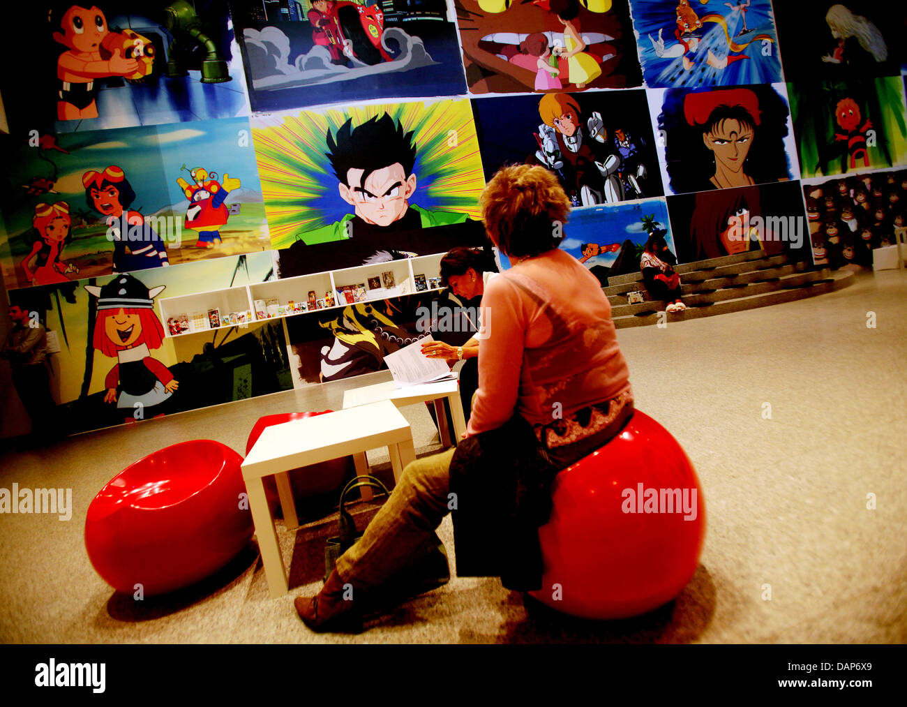 Una mujer mira a las tiras cómicas en el Salón de Arte y Exposiciones de la República Federal de Alemania (Bundeskunsthalle) en Bonn, Alemania, 28 de julio de 2011. Desde el 29 de julio de 2011 hasta el 08 de enero de 2012, el 'Anime! Arte - Cultura Pop' La exposición estará en la Bundeskunsthalle. Foto: Oliver Berg Foto de stock