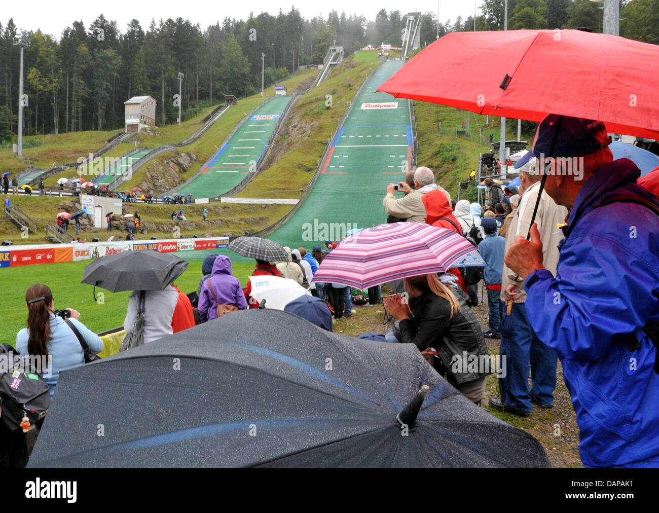 Los visitantes siguen la 30ª Summer Grand Prix en Hinterzarten con sombrillas, Alemania, 07 de agosto de 2011. Puente austríaco Morgenstern ganó por delante del puente de esquí Stoch polaco y alemán Freitag puente. Foto: Rolf Haid Foto de stock