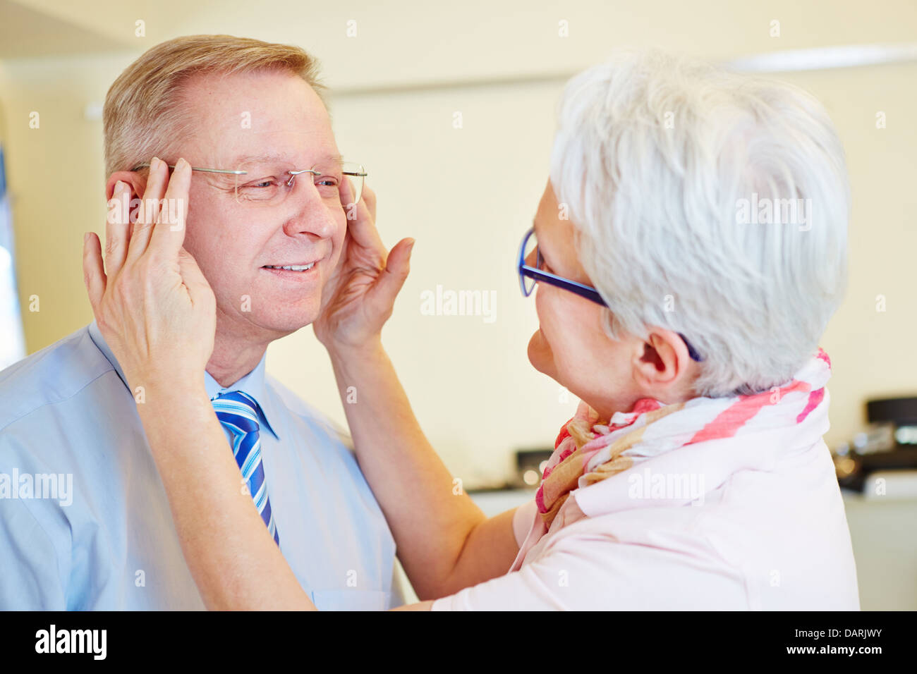 Hombre Senior probando nuevas gafas sin reborde en el óptico Foto de stock
