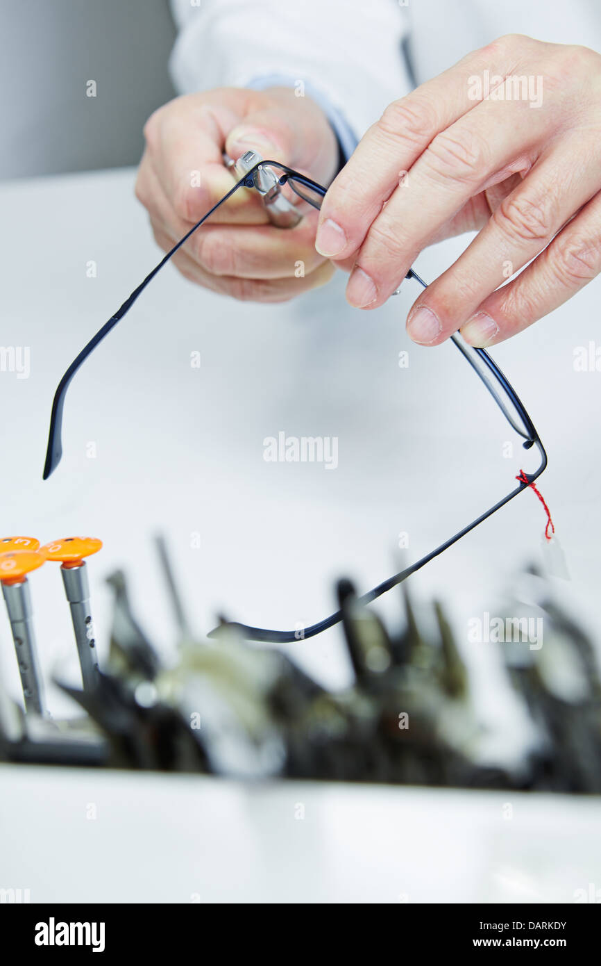 Taller de reparación de gafas a través de las manos de un óptico Foto de stock