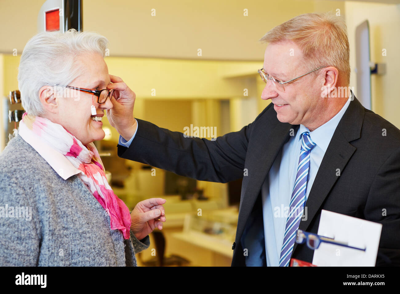 Ancianos mujer alegre y comprar nuevas gafas al almacén óptico Foto de stock