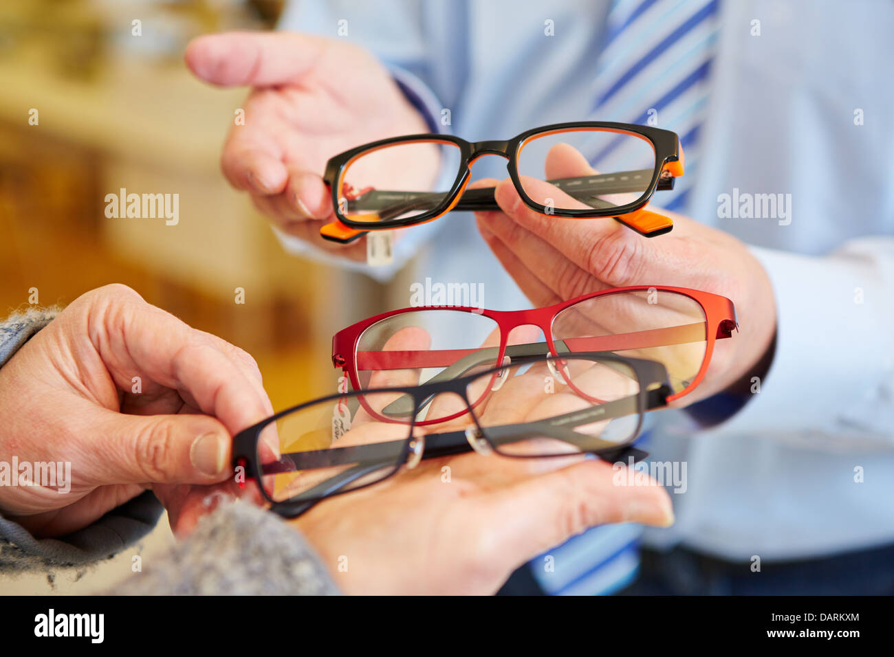 Óptico ofrece un cliente una variedad de gafas Foto de stock