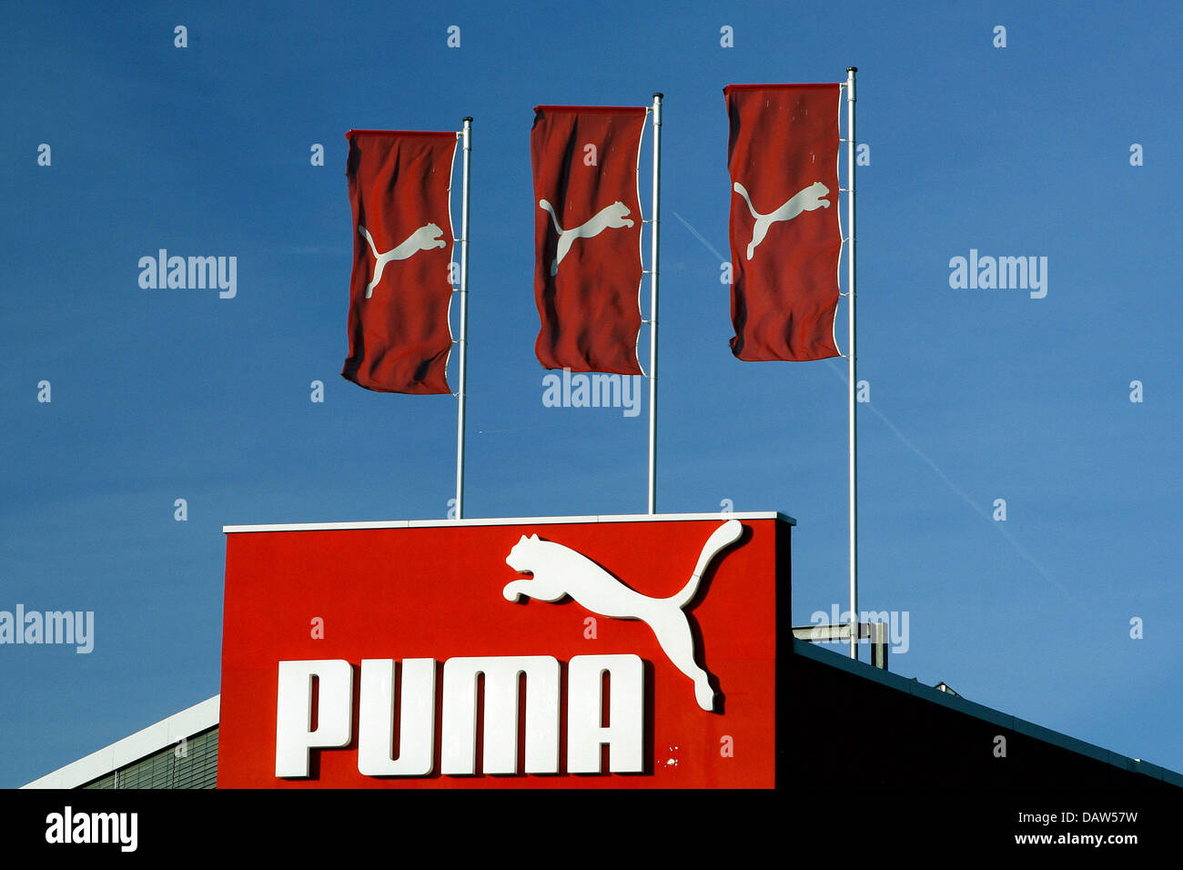 El logotipo de la empresa PUMA y tres banderas rojas con el logotipo de la  compañía en blanco se muestra en el techo de la tienda de la compañía en  Herzogenaurach, Alemania,
