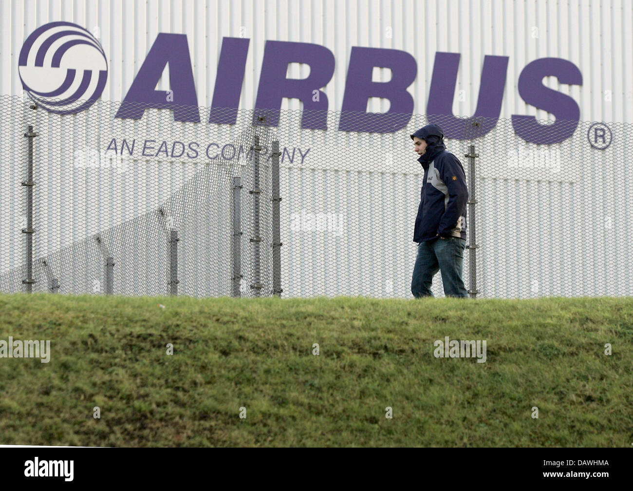 Archivo de datos (dpa) Un hombre camina más allá de la planta de Airbus Nordenham, Alemania, 06 de febrero de 2006. Foto: Ingo Wagner Foto de stock