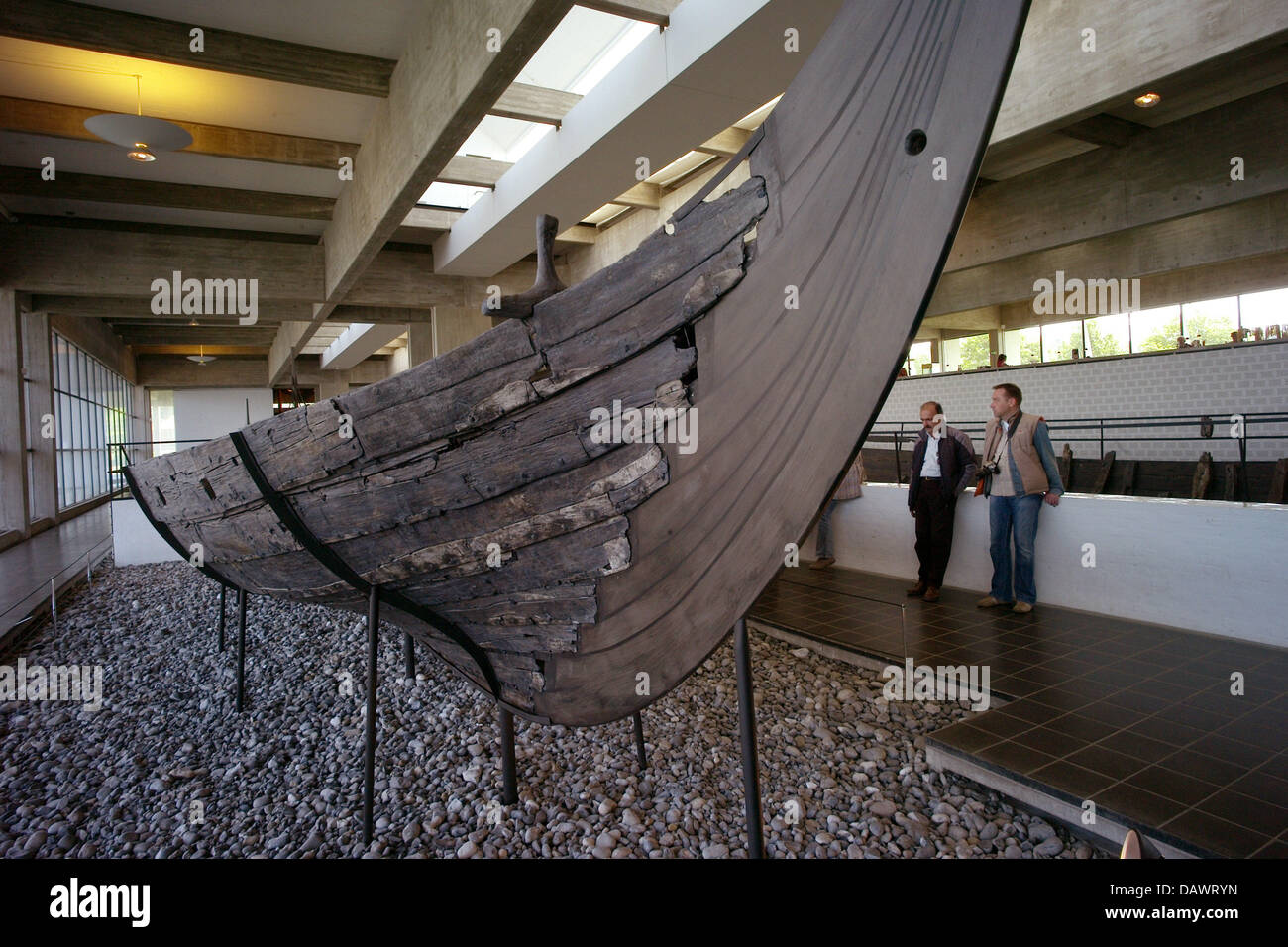 Los visitantes echar un vistazo a los barcos vikingos desde el siglo XI, descubrió en el fiordo de Roskilde en 1962, en el buque hall del museo de los Barcos Vikingos en Roskilde, Dinamarca, 22 de mayo de 2007. La construcción naval y la marina de los vikingos son presentados en el museo que tiene su propio muelle y un taller arqueológico y ofrece excursiones en barco barco vikingo en el verano. Foto: Maurizio Gambarini Foto de stock