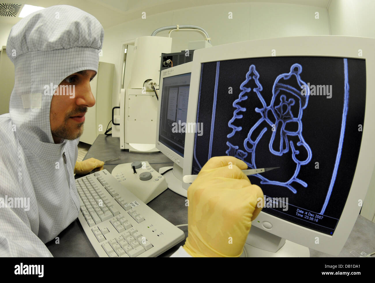 Daniel Neumaier de la Universidad de Regensburg, muestra la imagen de un muñeco de nieve que está grabado en el "Calendario de Adviento más pequeño del mundo" en Regensburg, Alemania, el 11 de diciembre de 2007. El calendario está grabado en el arseniuro de galio y es de 12*8 micrómetros. No es visible sin un microscopio especial. Foto: ARMIN WEIGEL Foto de stock