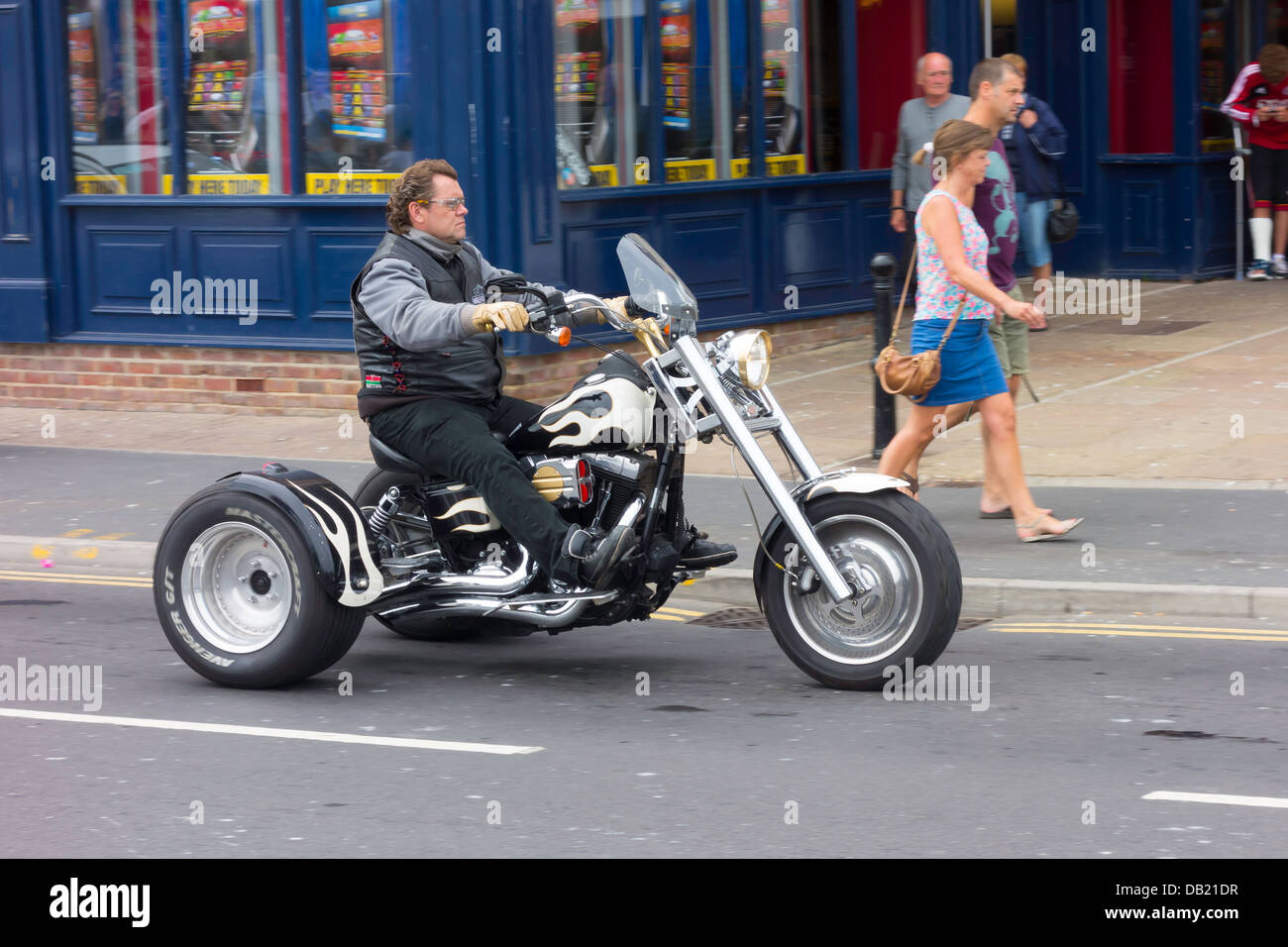 Hombre montando un motor personalizado triciclo en Whitby en Yorkshire del  norte en una tarde de verano Fotografía de stock - Alamy