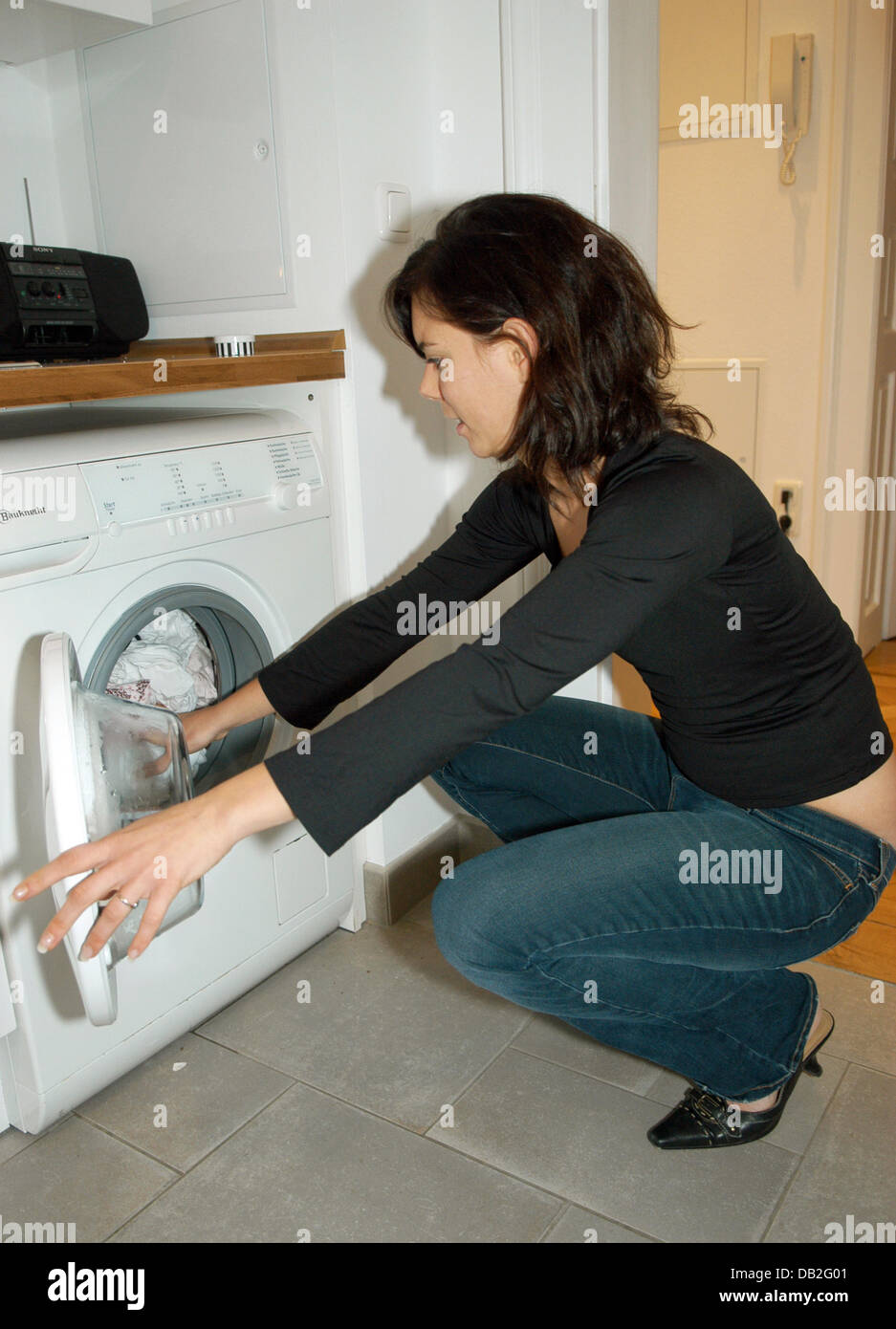 Sandra Sommer saca la ropa mojada de la lavadora en su apartamento en  Munich, Alemania, el 14 de diciembre de 2007. Foto: Felix Hoerhager  Fotografía de stock - Alamy