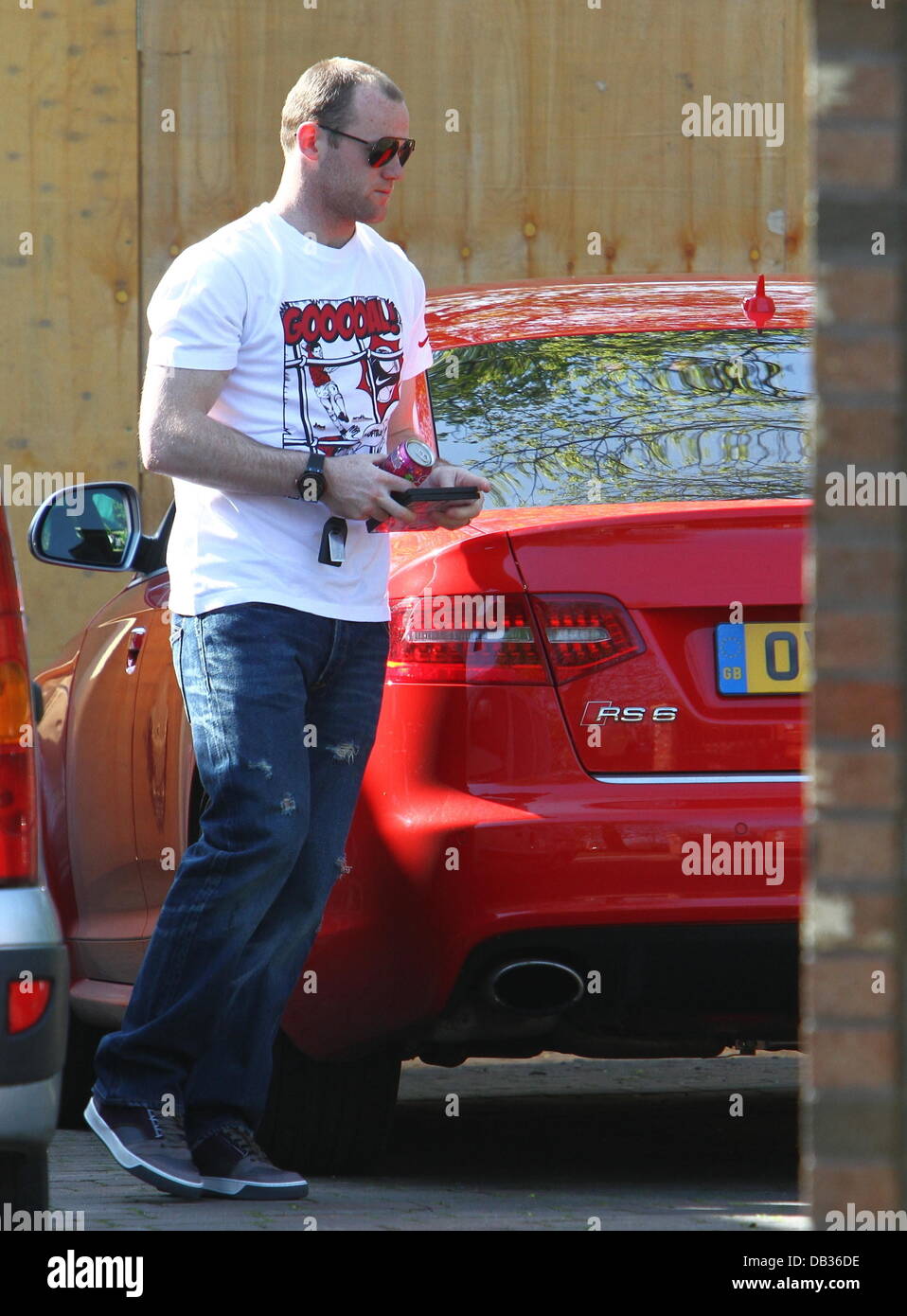 Wayne Rooney entrar en su coche a su esposa, casa de los padres del Nike  vistiendo una camiseta con la palabra "Goooal!" escrito en él. Liverpool,  Inglaterra - 09.04.11 Fotografía de stock - Alamy