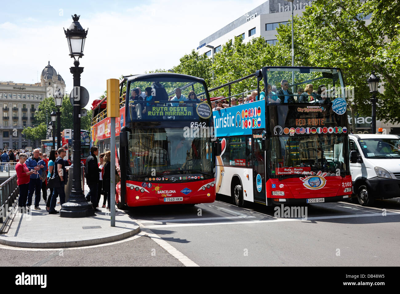 Compitiendo open top bus tours por la ciudad de Barcelona, Cataluña, España Foto de stock